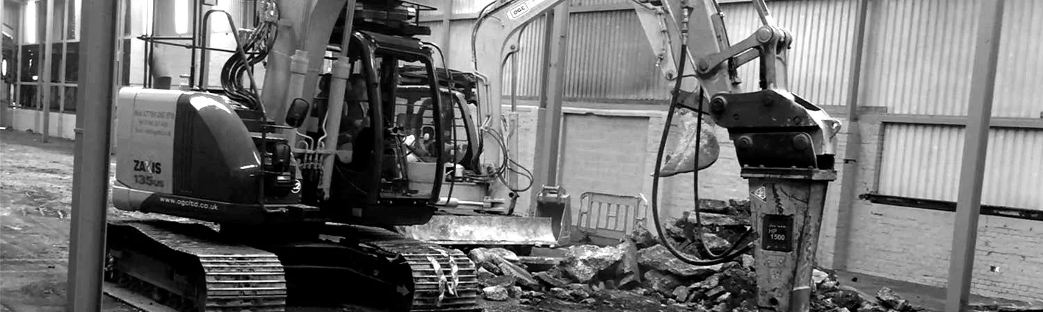 Excavators breaking out and loading inside an industrial building