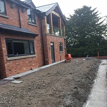 New detached brick house with external groundworks being prepared around it