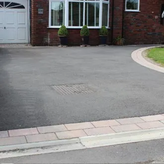 Tarmac driveway with a block paved edge in front of a house